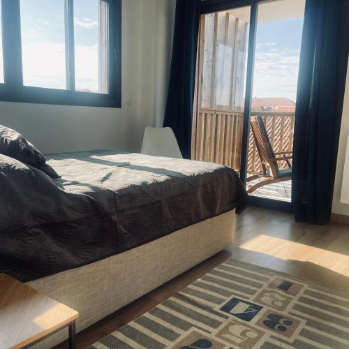 une chambre avec un lit et une vue sur un balcon dans l'établissement F3 à mimizan plage, à Mimizan-Plage