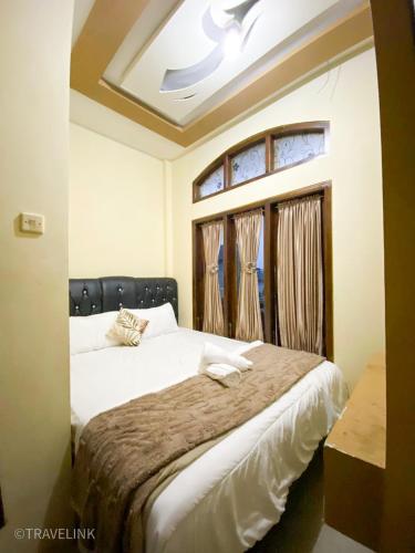 a bedroom with a large bed with a window at Dieng Travelink Inn in Banjarnegara