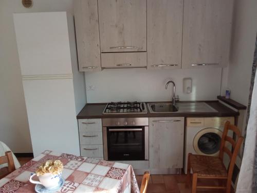 a kitchen with a table and a stove and a sink at Agriturismo Cele in Celle Ligure
