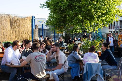 a group of people sitting at tables in a garden at La Chaumière in Nantes