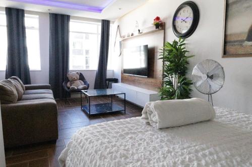 a living room with a bed and a clock on the wall at senator park in Cape Town