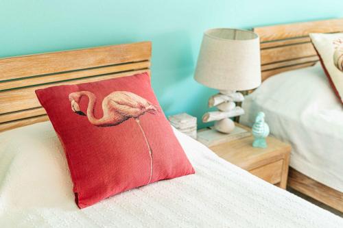 a red pillow with a flamingo on a bed at Orion Living - Walkable Facilities & Scenic View in Tamarin