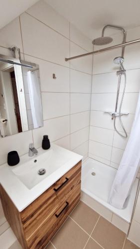 a white bathroom with a sink and a shower at Central apartment in Buchholz idN in Buchholz in der Nordheide