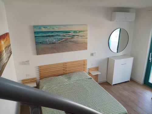 a small bedroom with a bed and a mirror at Eos affittacamere in Castelsardo