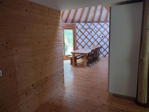 d'une salle à manger avec une table et un mur en bois. dans l'établissement Yourte contemporaine, à Geishouse