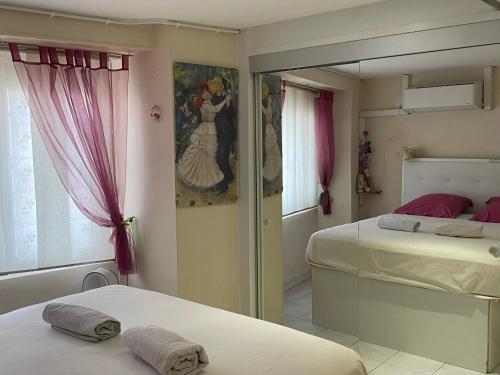 une chambre avec deux lits et un miroir dans l'établissement Climatisé, proche Palais des Festivals et des plages, à Cannes