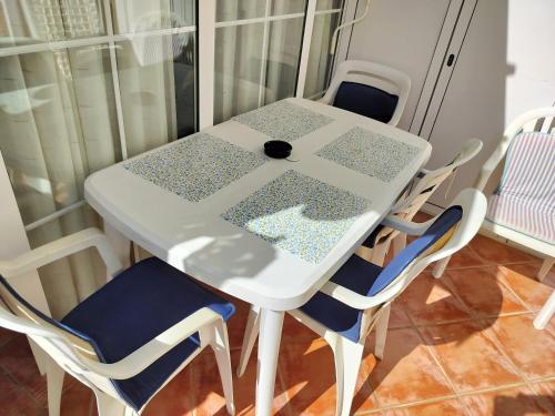 a table with chairs and a white table with a glass top at Arguinegin 2 bedroom apartment in Arguineguín