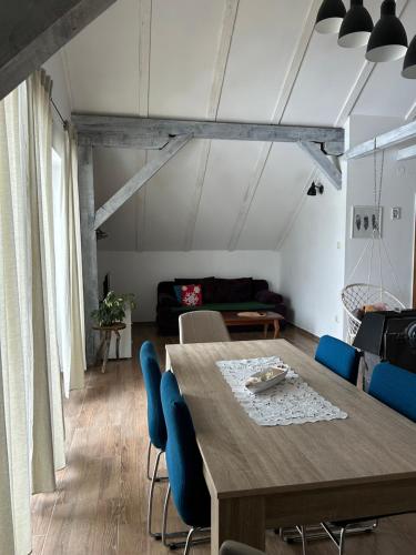 a living room with a wooden table and blue chairs at Planinski kutak in Lovinac