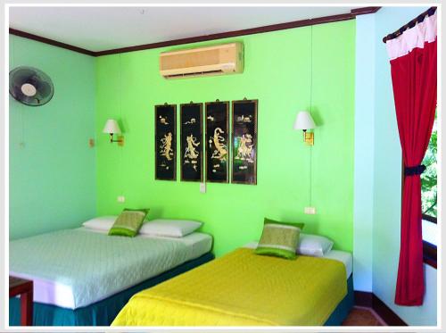 zwei Betten in einem Zimmer mit grünen Wänden in der Unterkunft The Emerald Krabi Beach Resort in Klong Muang Beach