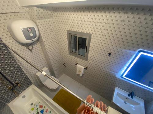 a small bathroom with a toilet and a tv on the wall at Résidence hôtelière MEDOM Palace, Bastos in Yaoundé