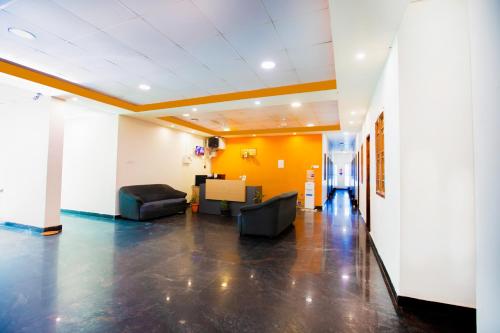 an office lobby with couches and a yellow wall at STARLIGHT HOTELs PUDUCHERRY in Puducherry