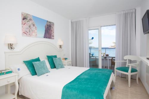 a hotel room with a bed and a view of the ocean at Hotel Marina in Port de Soller