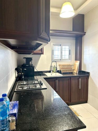 a kitchen with a sink and a stove top oven at Résidence ADE in Libreville