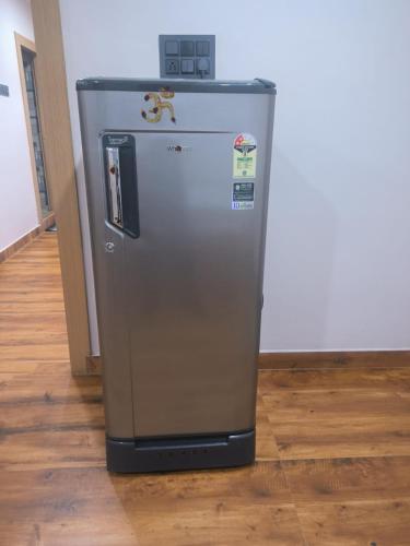 a small refrigerator is sitting on a wooden floor at Swagan Home Stays Air Conditioned Deluxe ONE BED ROOM Studio Apartment in Visakhapatnam