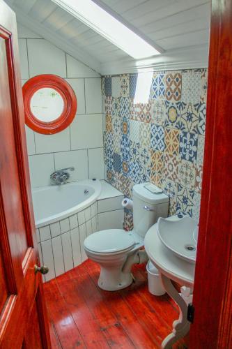 a bathroom with a toilet and a tub and a sink at The Fountain Villa in Klerksdorp