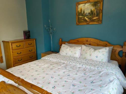 a bedroom with a bed and a painting on the wall at Welcome to Tunmobi Villa, its home away from home. in Ballyjamesduff