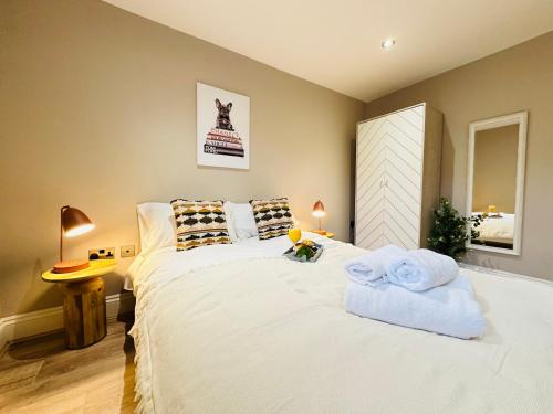 a bedroom with a large white bed with towels on it at Modern Living City Centre Spacious Apartments in Hull