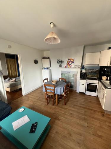 un salon avec une table et une cuisine dans l'établissement Appartement Cosy entre port et plage, à Dieppe