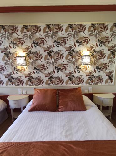 a bedroom with a bed with two lights on it at Le Pavillon Saint-Martin in Souillac