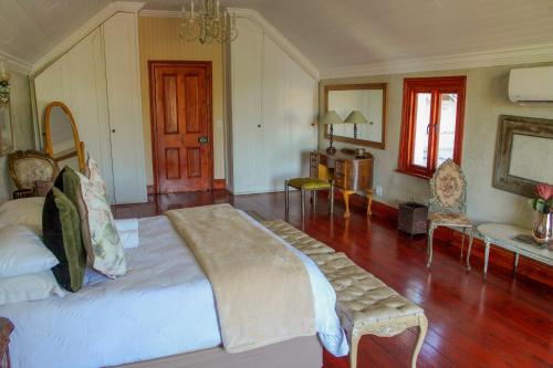 a bedroom with a large bed and wooden floors at The Fountain Villa in Klerksdorp
