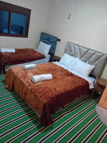 a bedroom with two beds with towels on the bed at Maison D'hôtes Chez Bassou Agoudal in Agoudal