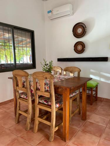 a dining room table with four chairs and a table at Las Potrancas cabaña in General Alvear