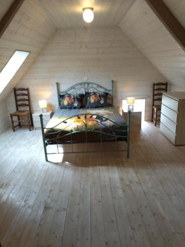 une chambre avec un grand lit dans un grenier dans l'établissement Gîte 2 personnes Auderville La Hague sur le GR223, à Saint-Germain-des-Vaux