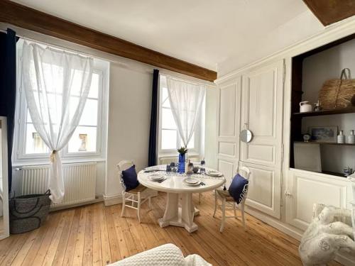 une salle à manger blanche avec une table et des chaises blanches dans l'établissement Le Santorin, à Mâcon