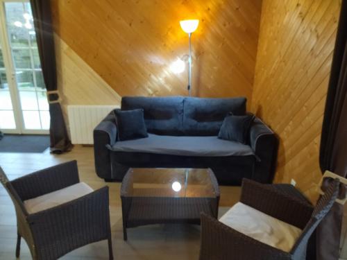 un salon avec un canapé bleu et des chaises dans l'établissement Gîte 2 personnes Auderville La Hague sur le GR223, à Saint-Germain-des-Vaux