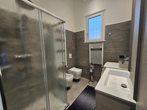 Un baño con ducha, inodoro y lavabo. en Le Conchiglie, en Marinella di Sarzana