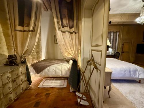a bedroom with a bed and a dresser and a door at Demeure des Vieux Bains in Provins