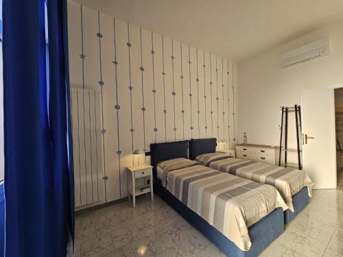 Un dormitorio con dos camas y una cortina azul. en Le Conchiglie, en Marinella di Sarzana
