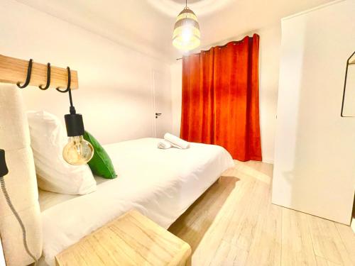 a bedroom with a white bed and a red curtain at Les Balcons de Chambéry in Chambéry