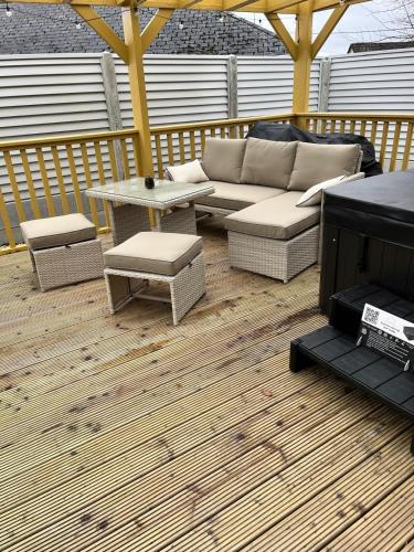 a patio with a couch and a table on a deck at Heirloom Lodge in Ballina