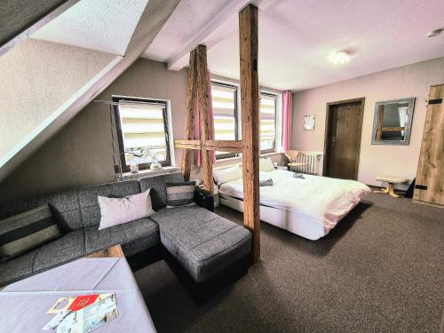a bedroom with a loft bed and a bed and a couch at Altstadt Pension Orchidee in Wernigerode