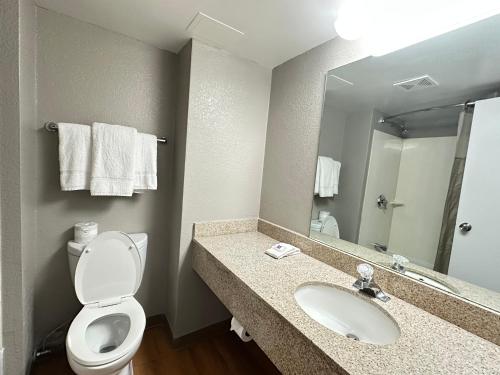 a bathroom with a toilet and a sink and a mirror at Studio 6 Springfield VA Washington DC Southwest in Springfield