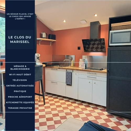 une cuisine avec des armoires blanches et un réfrigérateur noir dans l'établissement Le Clos De Marissel - Terrasse et Jardin, à Beauvais