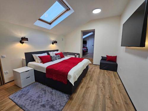 a bedroom with a bed with red pillows and a window at ApartHotel Ritms in Krāslava