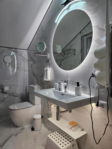 a white bathroom with a sink and a mirror at ApartHotel Ritms in Krāslava