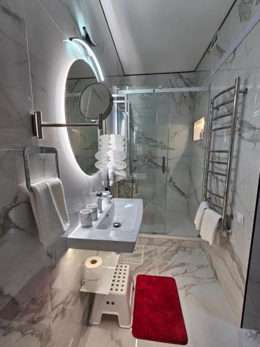a bathroom with a sink and a shower with a mirror at ApartHotel Ritms in Krāslava