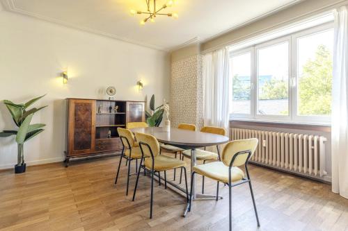 a dining room with a table and chairs at Elegant 2BR in Luxembourg with Balcony & WiFi in Luxembourg