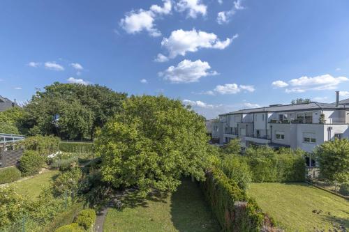 a garden with a tree and a building at Elegant 2BR in Luxembourg with Balcony & WiFi in Luxembourg