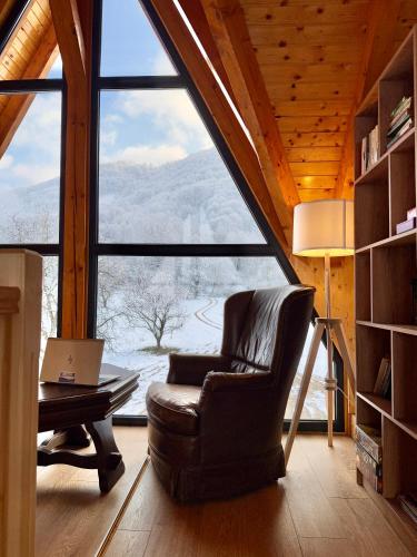 a living room with a chair and a table with a laptop at Cabana Forestia - ciubăr inclus in Copalnic Mănăştur