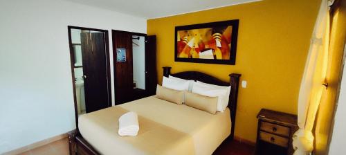 a bedroom with a bed with a yellow wall at Hotel Las Rocas Resort Villanueva in Villanueva
