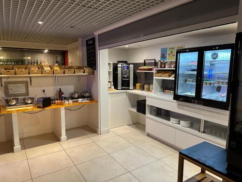 a shop with a counter with a counter at Brit Hotel Porte d'Espagne in Perpignan