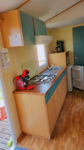 a small kitchen with a stove and a sink at Mobile home in Saint-Gérons