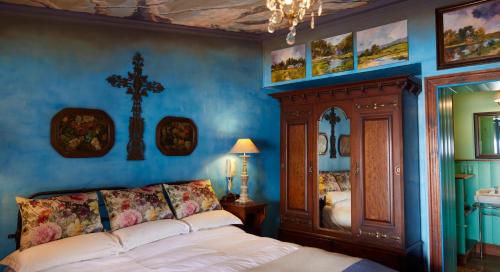 a bedroom with a bed and a cross on the wall at TwoAngels in Knysna