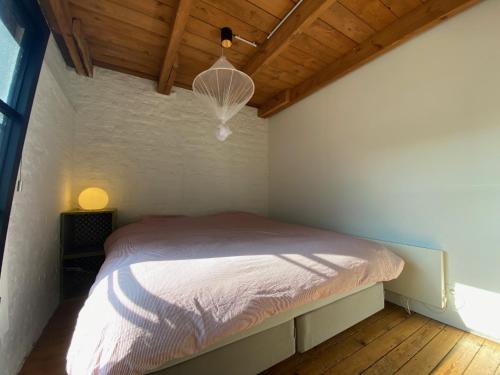 Cama en habitación pequeña con techo de madera en Cosy house 5 people, en Kontich
