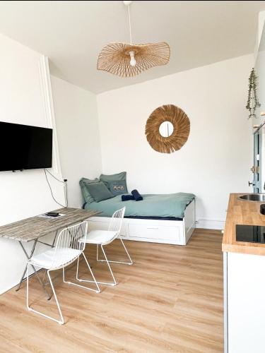 une chambre avec un lit, un bureau et des chaises dans l'établissement Le cocon bleu, à Dunkerque