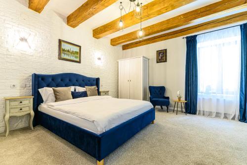 a bedroom with a blue bed and a blue chair at Dallure House Boutique Brasov in Braşov